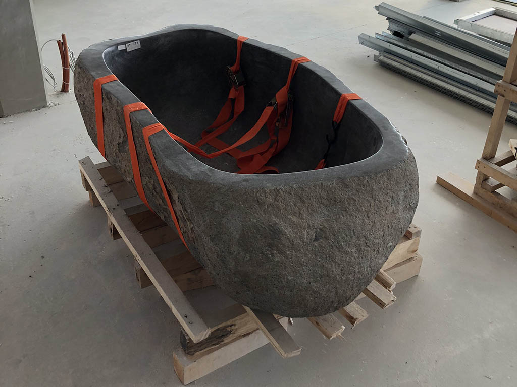 Tonnás kőből faragott kád raklapon, biztonságosan rögzítve