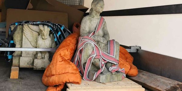 kőből faragott szobor szállítása teherautón, biztonságosan rögzítve