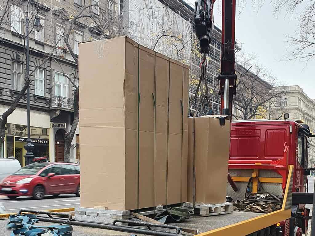 nehéz tárgy szállítása daruval városi környezetben